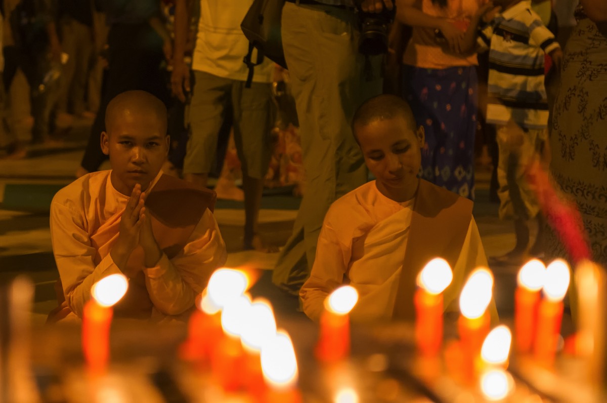 Nuns lighting candles at the Shwedagon Pagoda